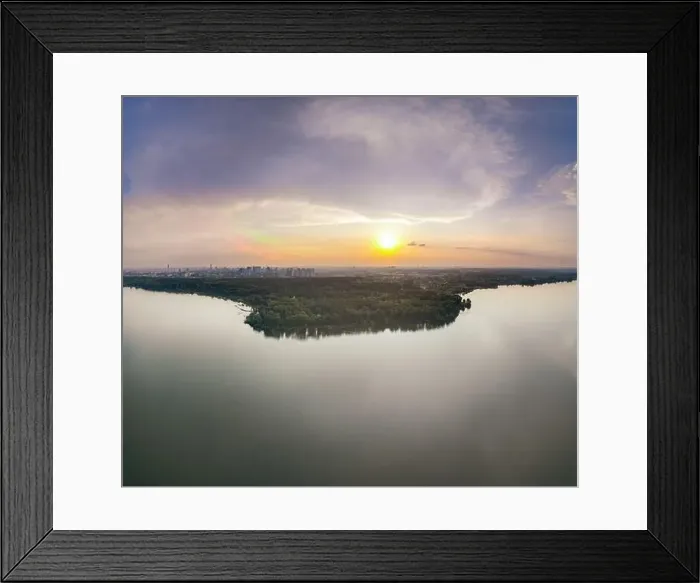 Framed Print : Big lake with green shores in bright sun light and city on horizon Framed Print : Big lake with green shores in bright sun light and city on horizon