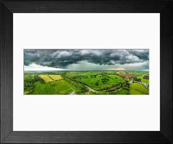 Framed Print : A powerful thunderstorm looms over expansive green fields in North Yorkshire Framed Print : A powerful thunderstorm looms over expansive green fields in North Yorkshire