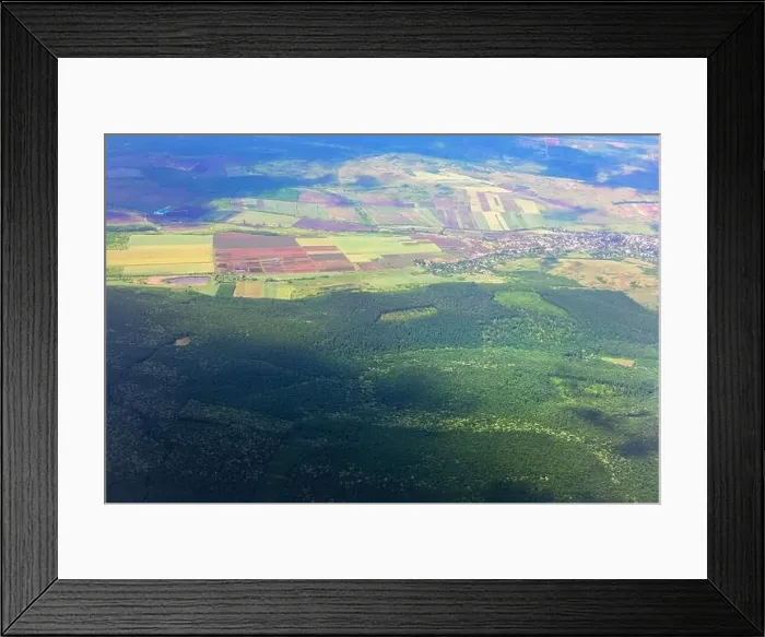 Framed Print : Aerial view of a forest with a village in the distance Framed Print : Aerial view of a forest with a village in the distance