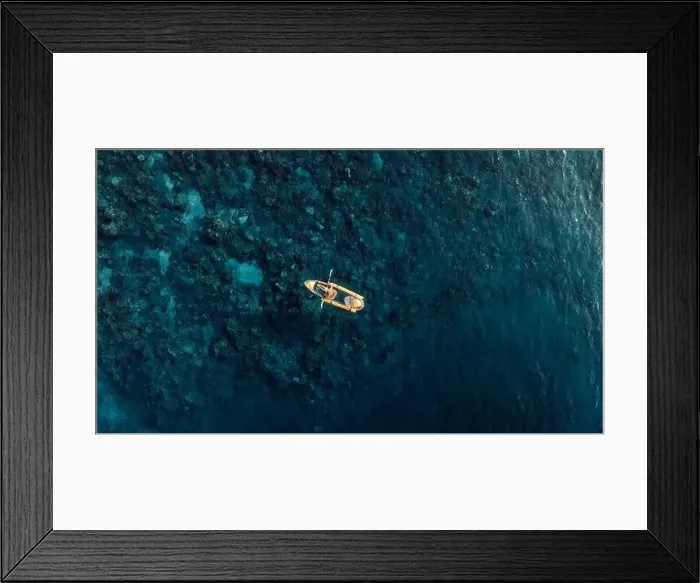 Framed Print : Woman kayaking in blue sea on transparent kayak. Drone view Framed Print : Woman kayaking in blue sea on transparent kayak. Drone view