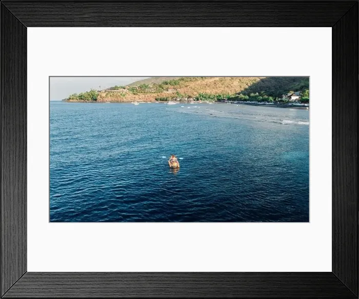 Framed Print : Woman kayaking in ocean on kayak near coastline. Drone view Framed Print : Woman kayaking in ocean on kayak near coastline. Drone view