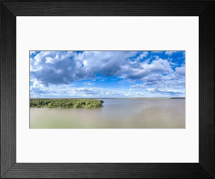 Framed Print : Big lake with green shores in bright sun light and city on horizon Framed Print : Big lake with green shores in bright sun light and city on horizon