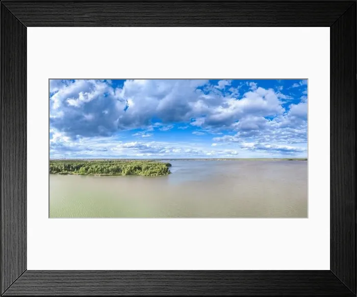 Framed Print : Big lake with green shores in bright sun light and city on horizon Framed Print : Big lake with green shores in bright sun light and city on horizon