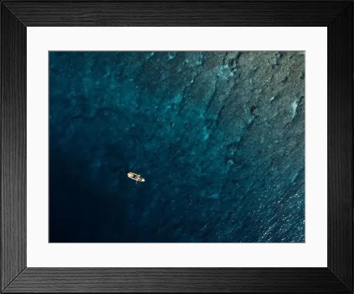 Framed Print : Woman swims on kayak in blue ocean. Drone view Framed Print : Woman swims on kayak in blue ocean. Drone view