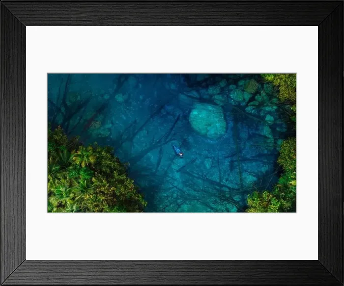 Framed Print : Woman floating on boat in transparent lake with crystal blue water in Indonesia. Aerial view Framed Print : Woman floating on boat in transparent lake with crystal blue water in Indonesia. Aerial view