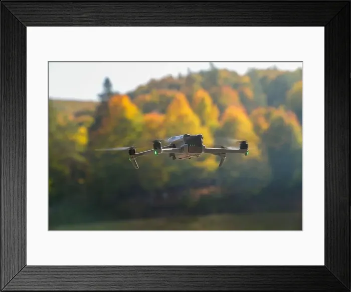 Framed Print : A drone is flying over a lake with trees in the background Framed Print : A drone is flying over a lake with trees in the background