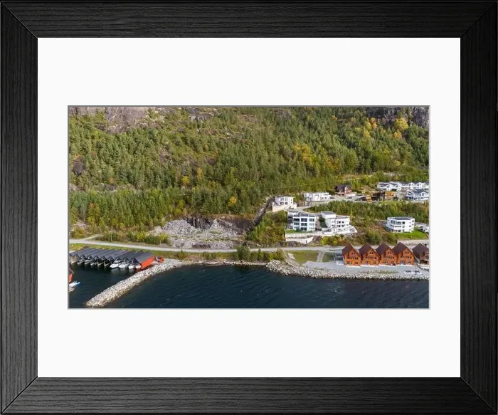 Framed Print : Aerial view of a coastal village with wooden houses along a fjord, surrounded by forested hills in autumn colors Framed Print : Aerial view of a coastal village with wooden houses along a fjord, surrounded by forested hills in autumn colors