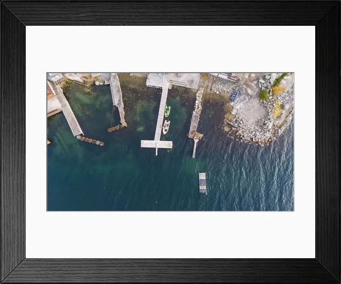 Framed Print : An aerial view of a serene coastal area featuring wooden docks extending into clear blue waters Framed Print : An aerial view of a serene coastal area featuring wooden docks extending into clear blue waters