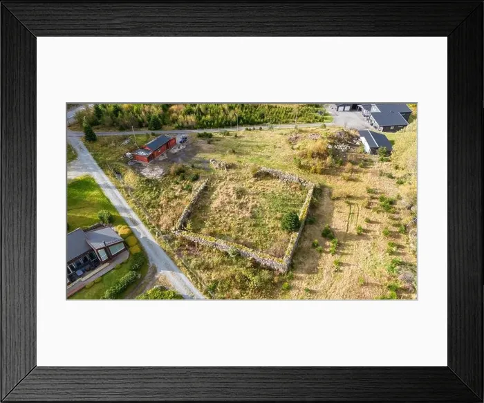 Framed Print : An aerial view of an empty plot of land surrounded by greenery and structures Framed Print : An aerial view of an empty plot of land surrounded by greenery and structures