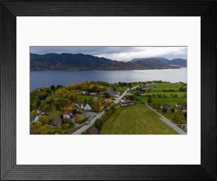 Framed Print : Aerial view of a serene fjord landscape with a small village nestled along the shore Framed Print : Aerial view of a serene fjord landscape with a small village nestled along the shore