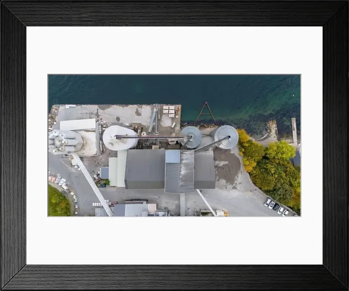 Framed Print : Aerial view of a small factory with solar panels on roof near a fjord in Norway Framed Print : Aerial view of a small factory with solar panels on roof near a fjord in Norway
