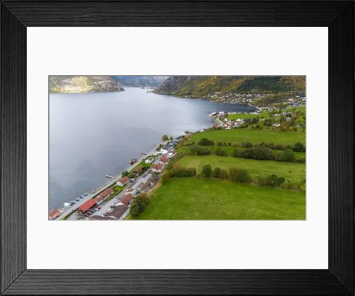 Framed Print : Aerial view of a serene fjord landscape with a small village nestled along the shore Framed Print : Aerial view of a serene fjord landscape with a small village nestled along the shore