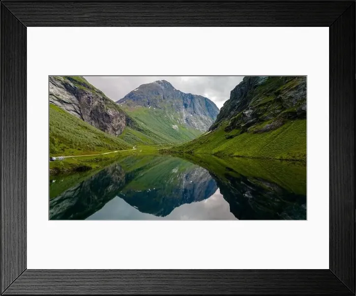 Framed Print : A serene lake nestled amidst the towering mountains of Norway Framed Print : A serene lake nestled amidst the towering mountains of Norway