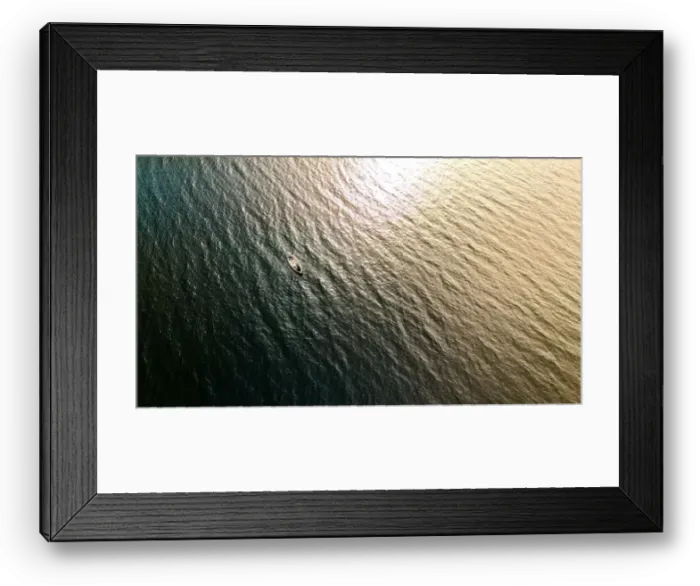 Framed Print : A small boat rests on the rippling waters of a lake in Finnish Lapland, bathed in the warm glow of the setting sun Framed Print : A small boat rests on the rippling waters of a lake in Finnish Lapland, bathed in the warm glow of the setting sun