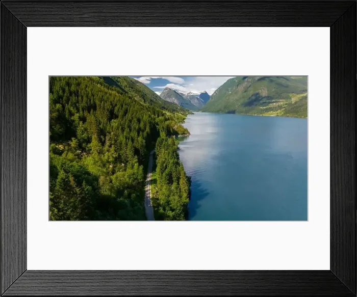 Framed Print : A scenic road winds through a lush green forest Framed Print : A scenic road winds through a lush green forest