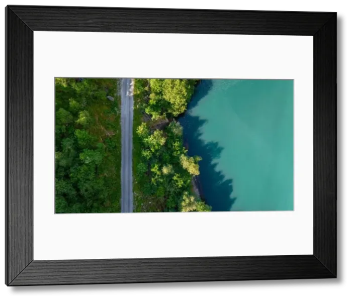 Framed Print : An aerial view of a winding road through lush green forest Framed Print : An aerial view of a winding road through lush green forest