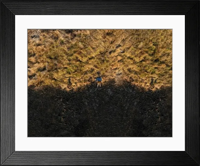 Framed Print : A man in the center of a pasture destroyed by wildfire Framed Print : A man in the center of a pasture destroyed by wildfire