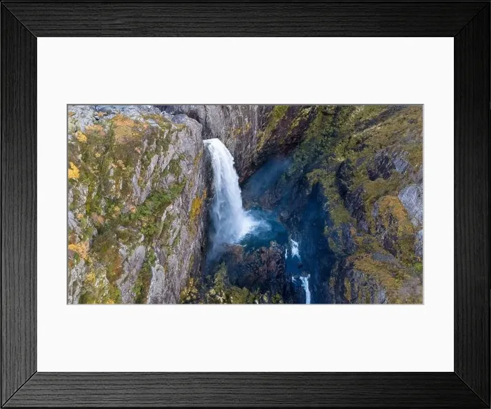 Framed Print : Aerial view of a stunning waterfall cascading down rocky cliffs into a deep blue pool surrounded by lush greenery Framed Print : Aerial view of a stunning waterfall cascading down rocky cliffs into a deep blue pool surrounded by lush greenery