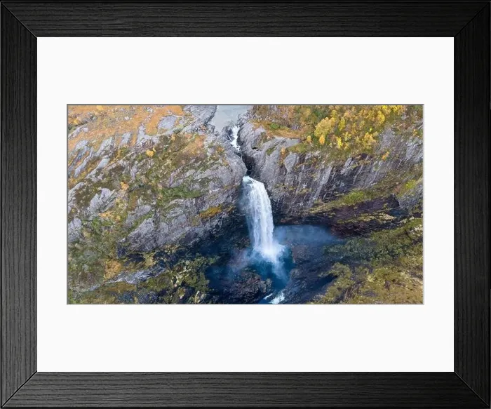 Framed Print : Aerial view of a stunning waterfall cascading down rocky cliffs into a deep blue pool surrounded by lush greenery Framed Print : Aerial view of a stunning waterfall cascading down rocky cliffs into a deep blue pool surrounded by lush greenery
