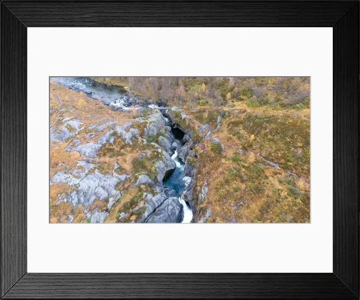 Framed Print : Aerial view of a rocky landscape with a river flowing through a narrow gorge surrounded by autumn foliage