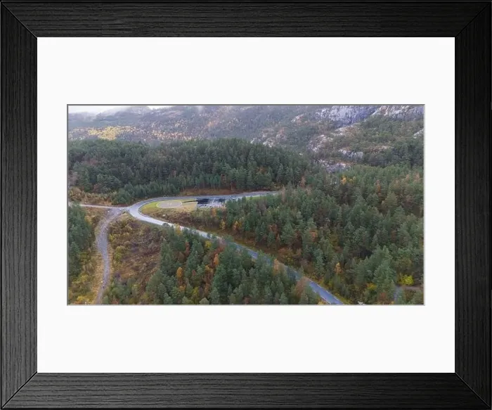 Framed Print : Aerial view of a winding road through a dense forest with autumn foliage Framed Print : Aerial view of a winding road through a dense forest with autumn foliage