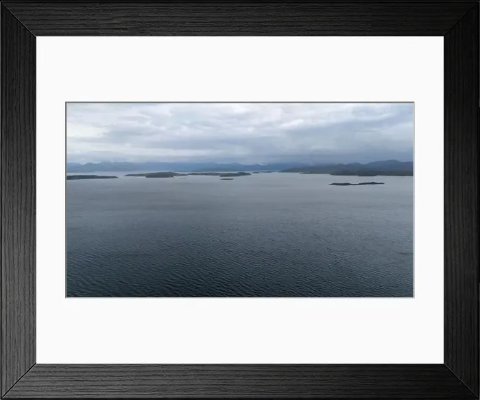 Framed Print : A serene view of a large body of water with small islands scattered across the horizon under a cloudy sky Framed Print : A serene view of a large body of water with small islands scattered across the horizon under a cloudy sky