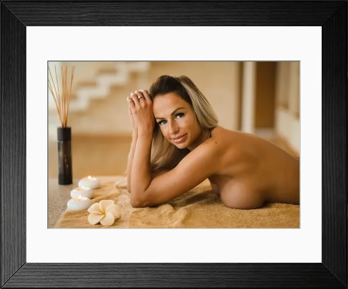 Framed Print : Blonde woman relaxing in beauty salon lying on massage table with candles and aroma sticks Framed Print : Blonde woman relaxing in beauty salon lying on massage table with candles and aroma sticks