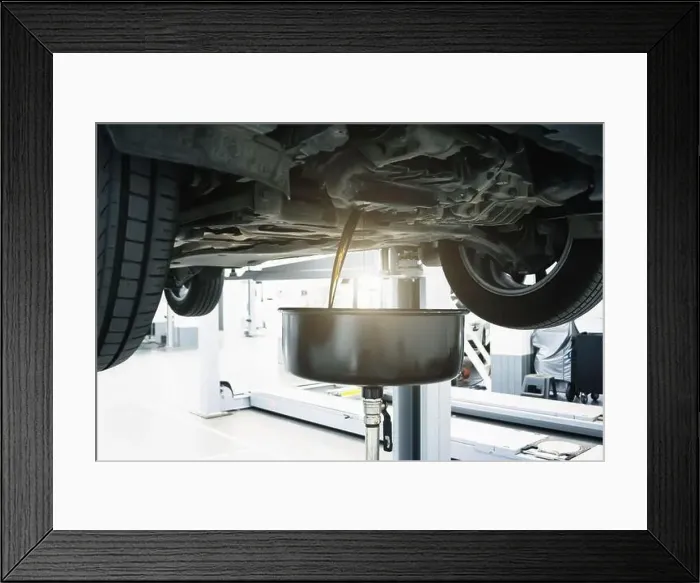 Framed Print : Engine oil change in car service. Auto is on hydraulic lift in garage workshop, process of draining old dark used oil Framed Print : Engine oil change in car service. Auto is on hydraulic lift in garage workshop, process of draining old dark used oil