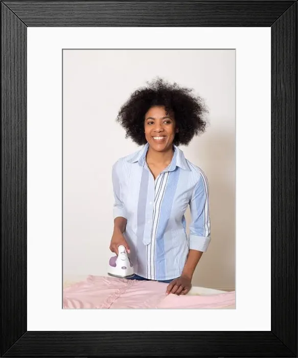 Framed Print : young woman ironing her clothes at home Framed Print : young woman ironing her clothes at home