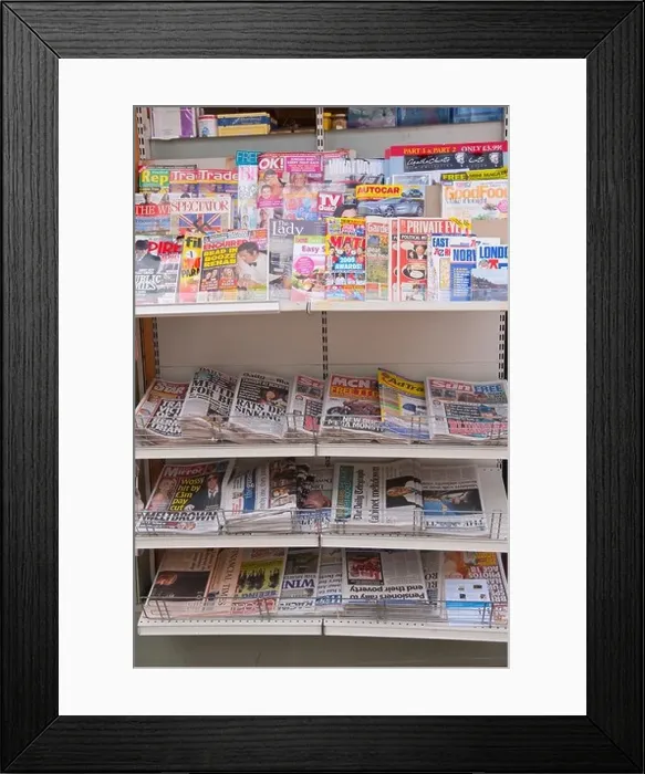 Framed Print : English Newspapers and glossy magazines on a shelf for sale in a Uk newsagents shop store Framed Print : English Newspapers and glossy magazines on a shelf for sale in a Uk newsagents shop store