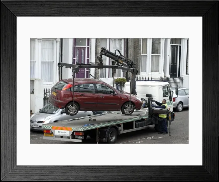 Framed Print : Car being hoisted on to tow away truck in Camden London