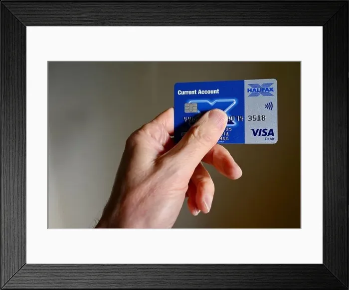 Framed Print : Close-up of senior man holding a Halifax debit card Framed Print : Close-up of senior man holding a Halifax debit card