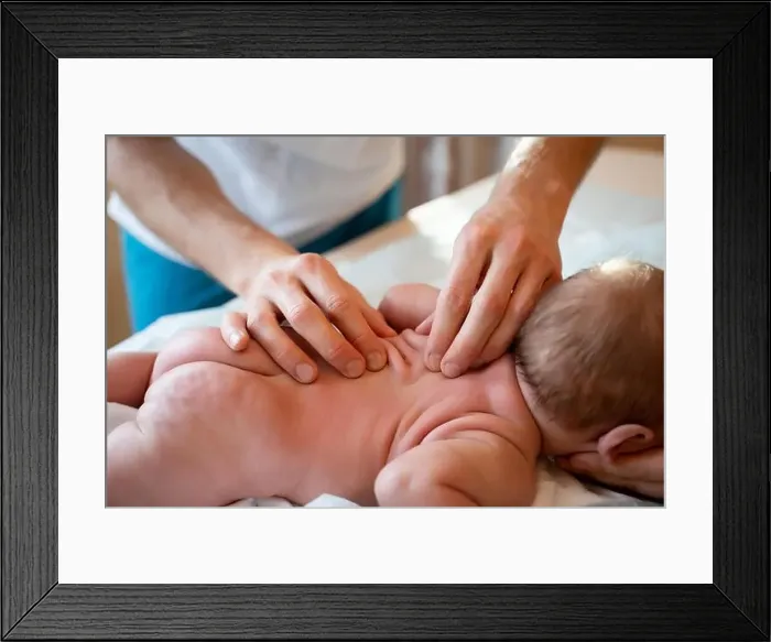 Framed Print : Picture from above of newborn baby and masseur hands Framed Print : Picture from above of newborn baby and masseur hands