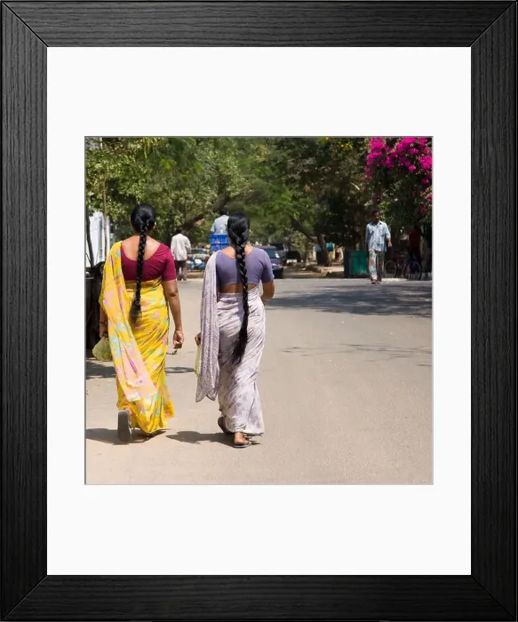 Framed Print : Two Indian woman with long plats dressed with saris walking on the street Framed Print : Two Indian woman with long plats dressed with saris walking on the street