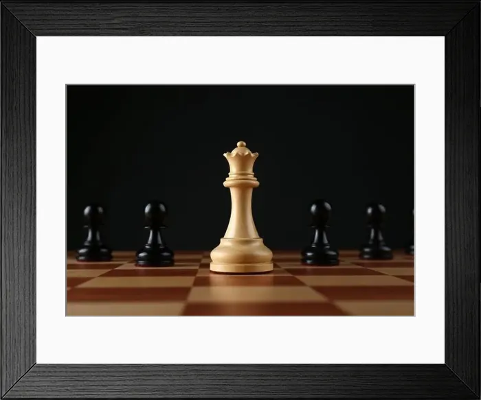 Framed Print : White queen among black pawns on wooden chess board against dark background Framed Print : White queen among black pawns on wooden chess board against dark background