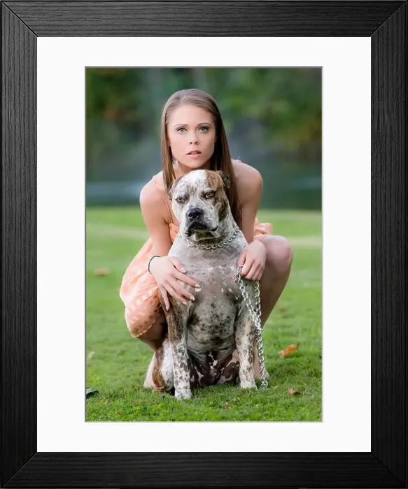 Framed Print : Cute young female poses with dog, late afternoon in the park Framed Print : Cute young female poses with dog, late afternoon in the park