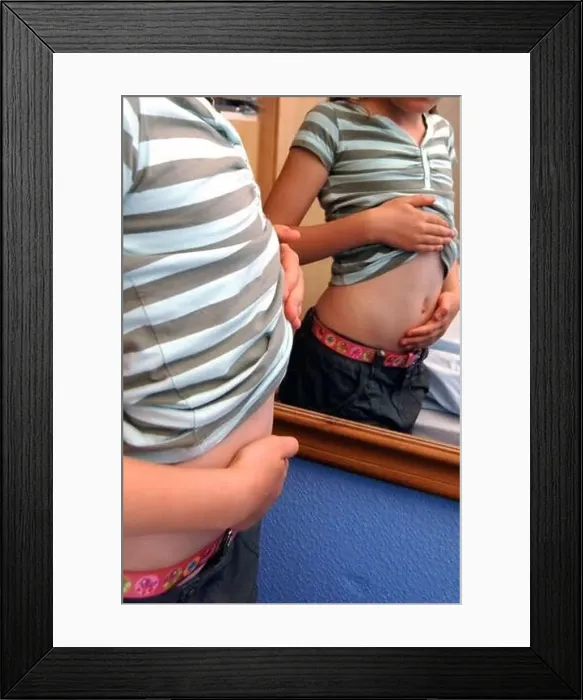 Framed Print : Girl looking at her tummy in a mirror Framed Print : Girl looking at her tummy in a mirror