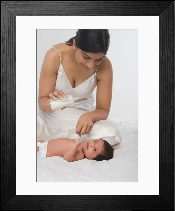 Framed Print : Woman checking milk before feeding her baby Framed Print : Woman checking milk before feeding her baby