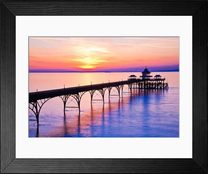 Framed Print : The sun sets over the Bristol Channel behind the Pier at Clevedon, Somerset, England, UK Framed Print : The sun sets over the Bristol Channel behind the Pier at Clevedon, Somerset, England, UK