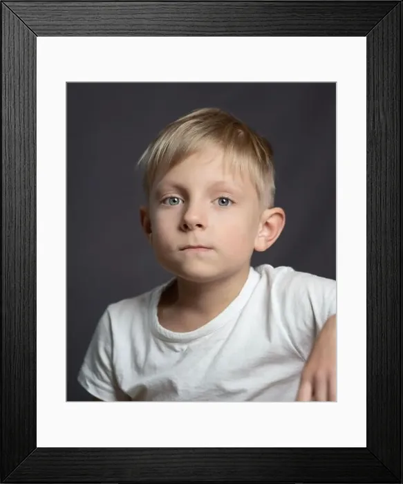 Framed Print : Studio portrait of a blue-eyed blonde sad caucasian boy looking at the camera Framed Print : Studio portrait of a blue-eyed blonde sad caucasian boy looking at the camera
