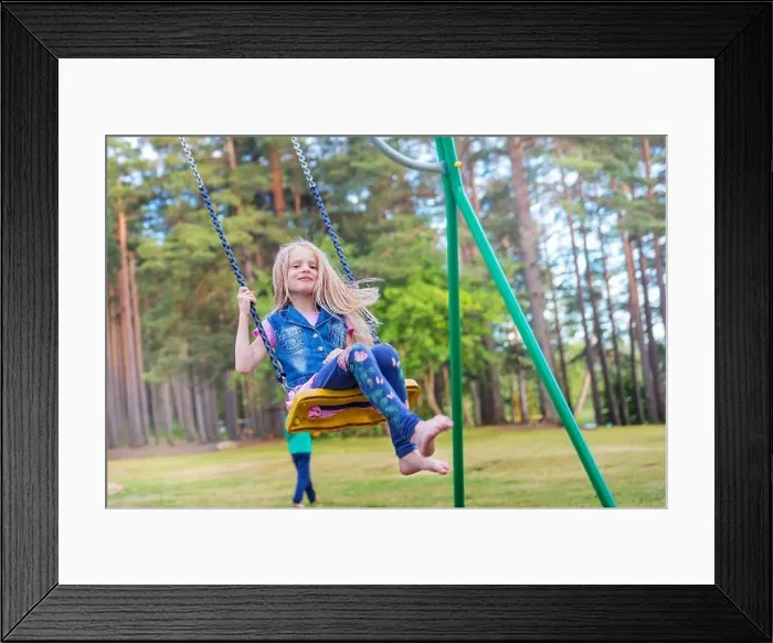 Framed Print : Pretty little blonde girl swinging outdoors on playground Framed Print : Pretty little blonde girl swinging outdoors on playground