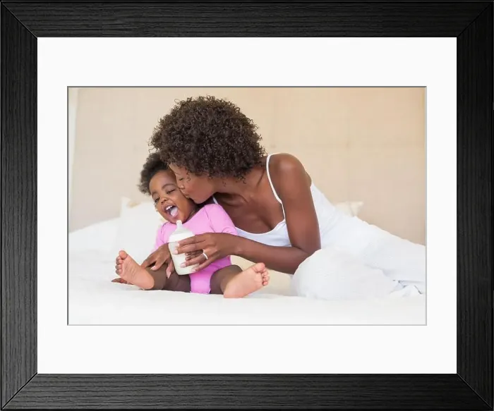Framed Print : Happy parents with baby girl on their bed Framed Print : Happy parents with baby girl on their bed