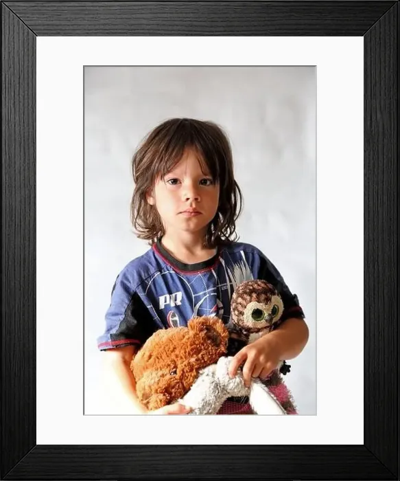 Framed Print : Portrait of 8 year old boy, with long hair wearing his pyjamas and holding some soft toys Framed Print : Portrait of 8 year old boy, with long hair wearing his pyjamas and holding some soft toys