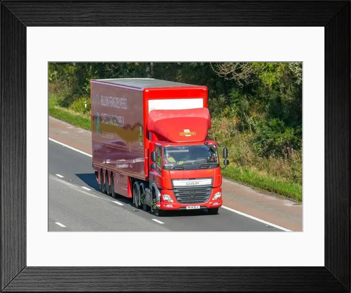 Framed Print : DAF CF Motorway. Red articulated trailer driving on UK motorway advertising its16 billions items delivered every year Framed Print : DAF CF Motorway. Red articulated trailer driving on UK motorway advertising its16 billions items delivered every year