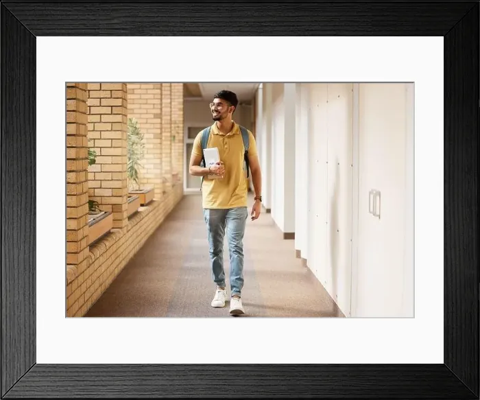 Framed Print : University student, college and indian man walking with a smile and backpack down campus corridor Framed Print : University student, college and indian man walking with a smile and backpack down campus corridor