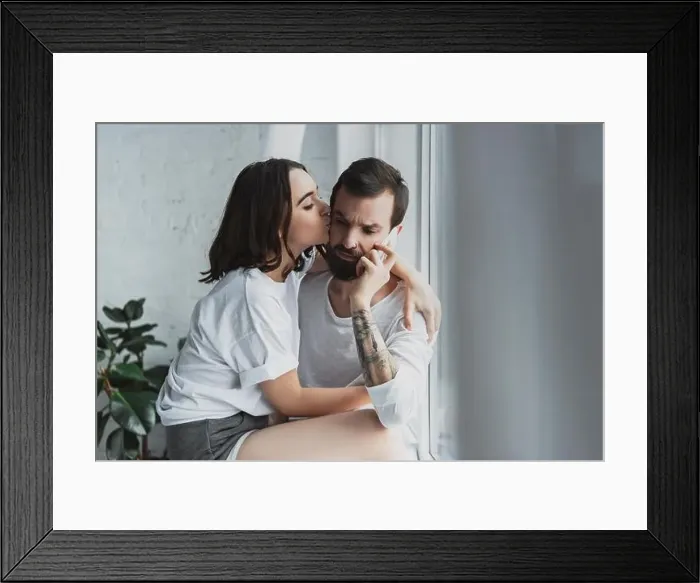 Framed Print : beautiful woman kissing man talking on smartphone at home Framed Print : beautiful woman kissing man talking on smartphone at home