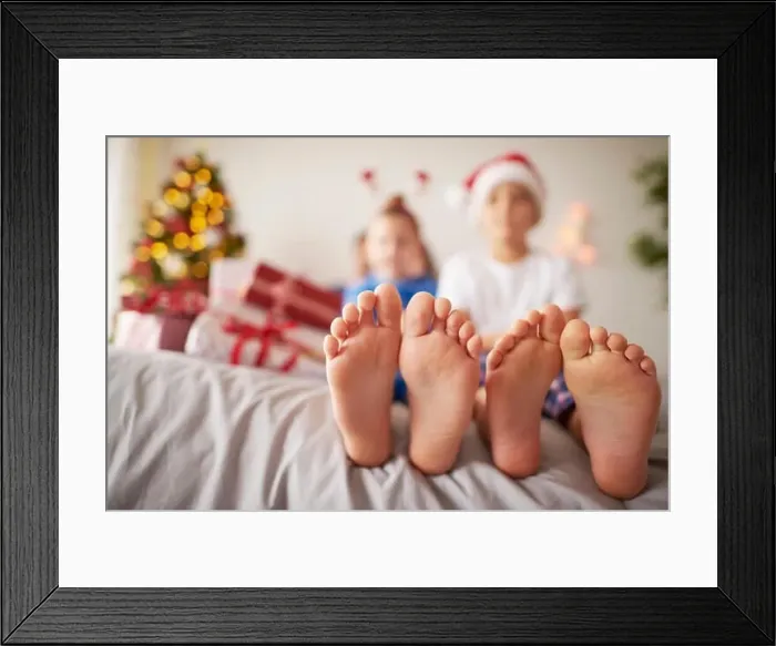 Framed Print : Kids feet in the bed at Christmas