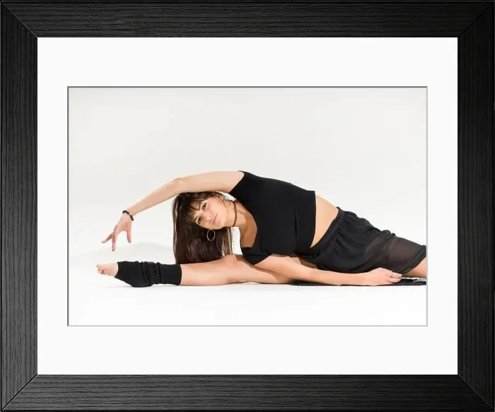 Framed Print : Supple attractive young female dancer doing a middle split with arm stretching exercise in a close up cropped frontal Framed Print : Supple attractive young female dancer doing a middle split with arm stretching exercise in a close up cropped frontal