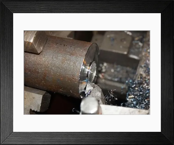 Framed Print : Turning operation. Cutting the end of a metal bar on a lathe. Close-up Framed Print : Turning operation. Cutting the end of a metal bar on a lathe. Close-up