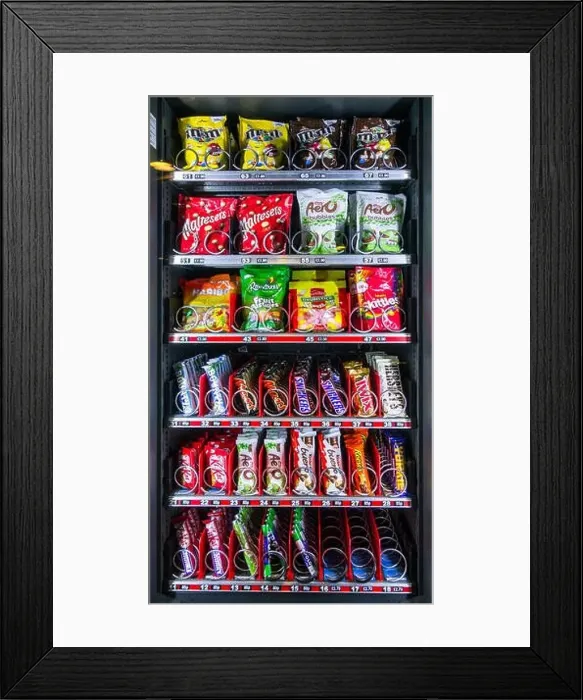 Framed Print : Snack vending machine / snack dispenser selling colourful sweets and chocolate bars in public place Framed Print : Snack vending machine / snack dispenser selling colourful sweets and chocolate bars in public place